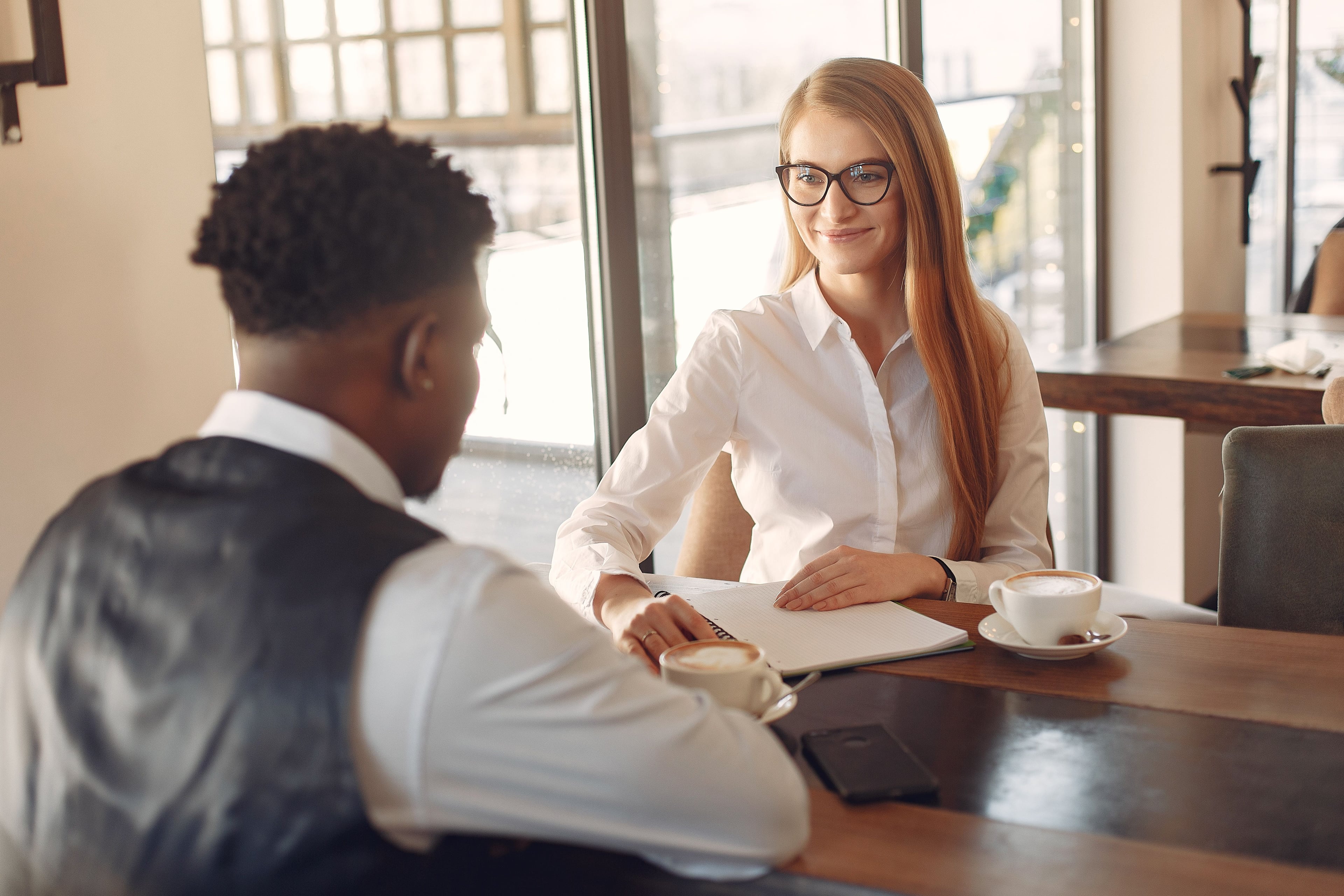 An interviewer listening to a candidate across a table.