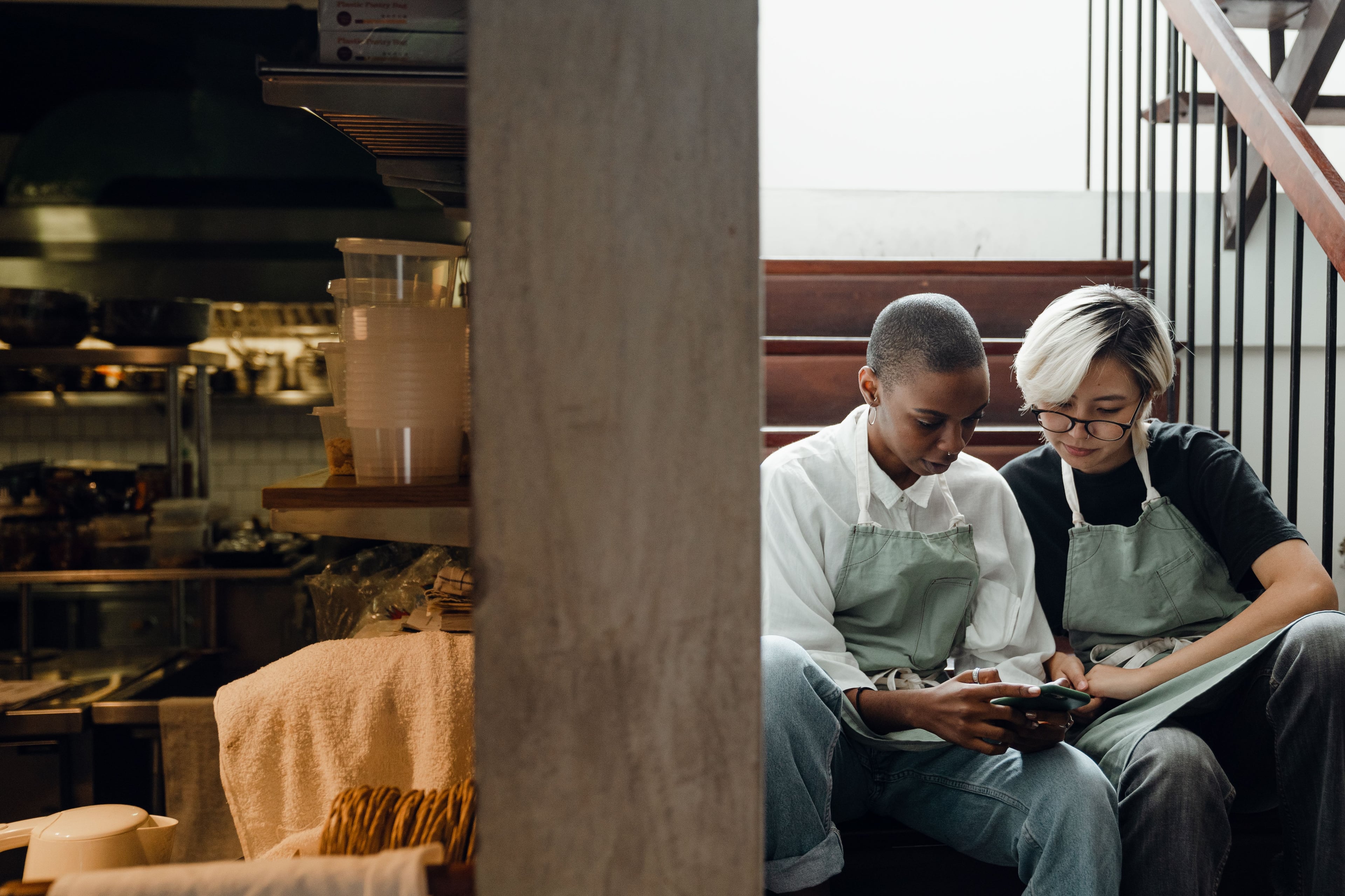 Two restaurant colleagues reviewing information together during a break.