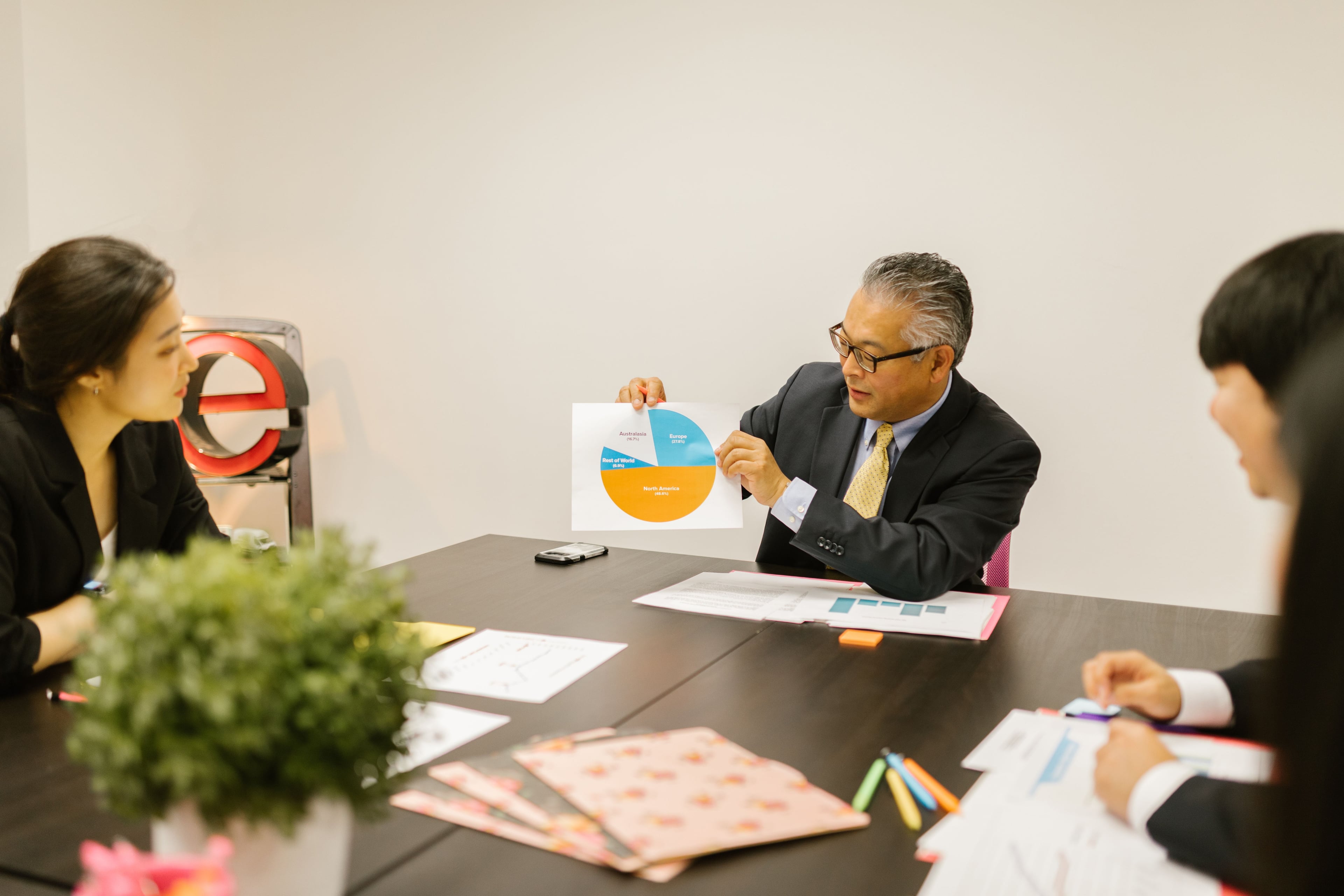 A colleague explaining a printed chart during a meeting
