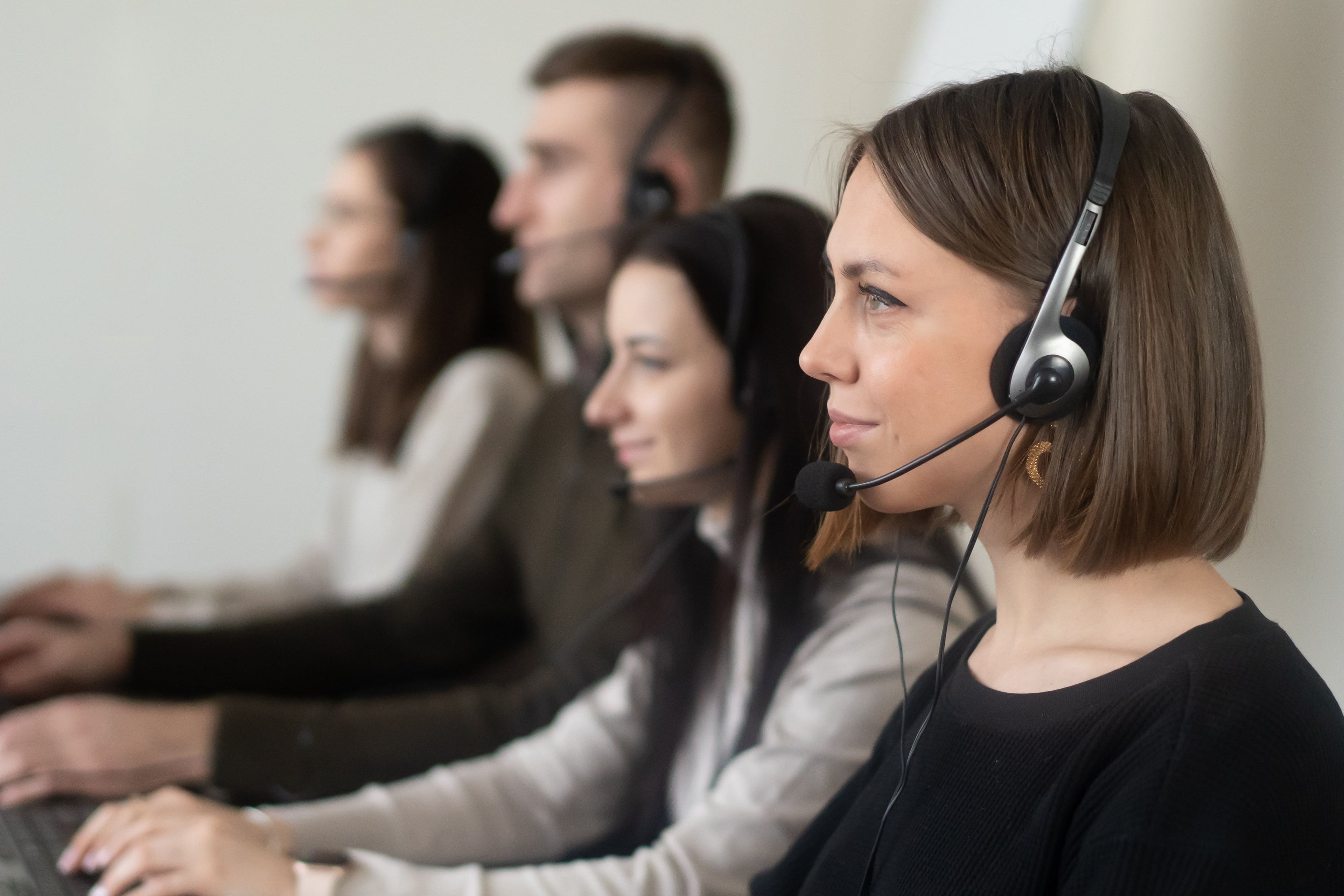 Customer service colleagues using headsets at their desks