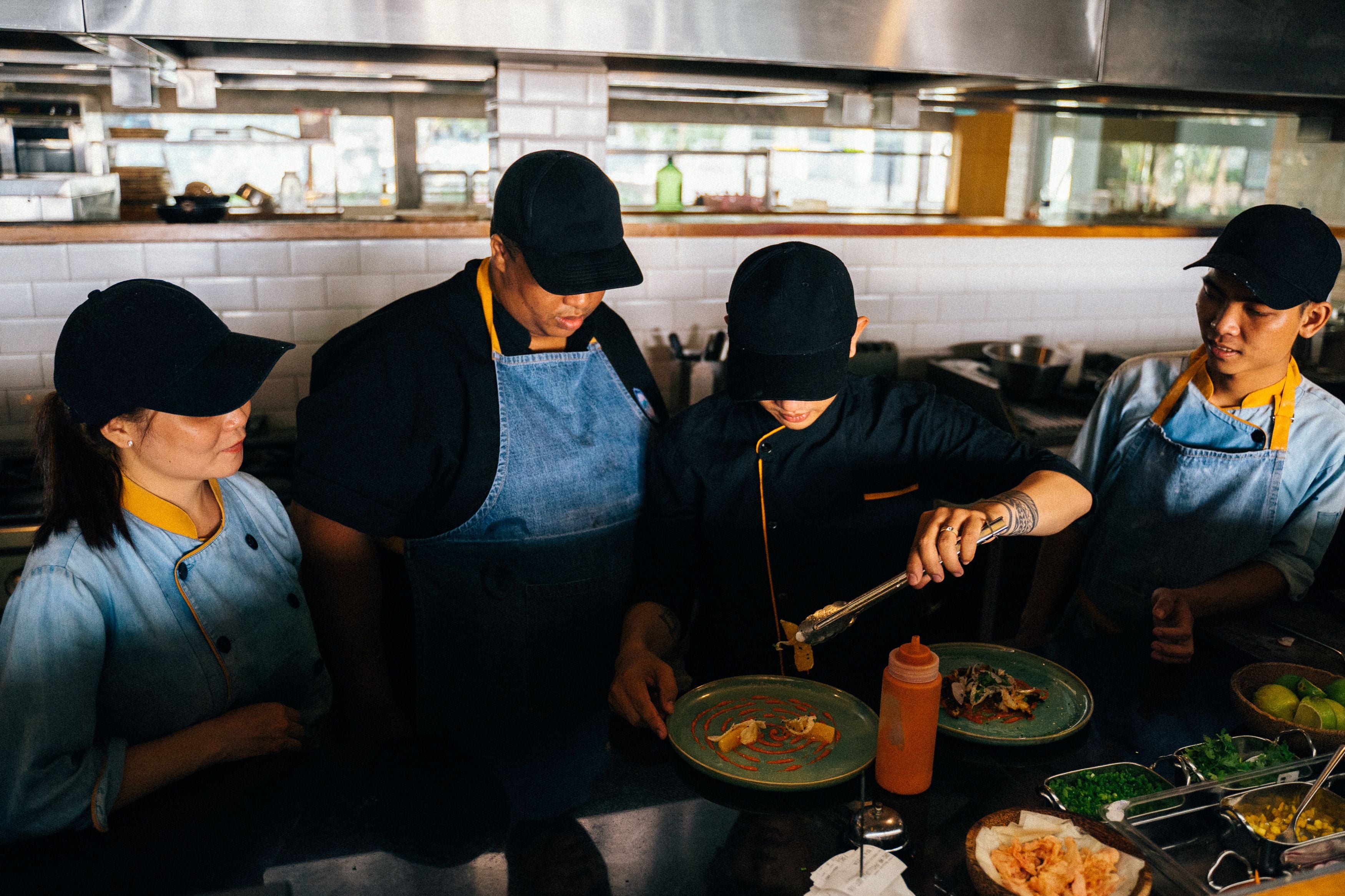 Kitchen colleagues learning a plating technique together
