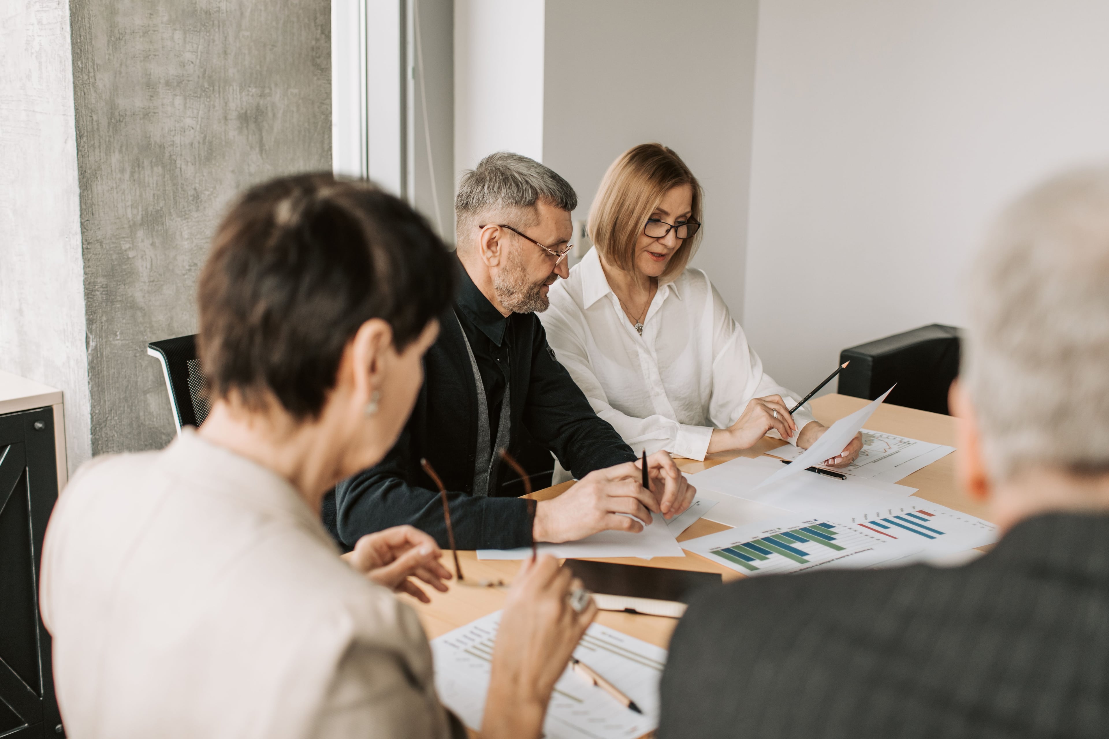 Experienced colleagues reviewing documents around a table