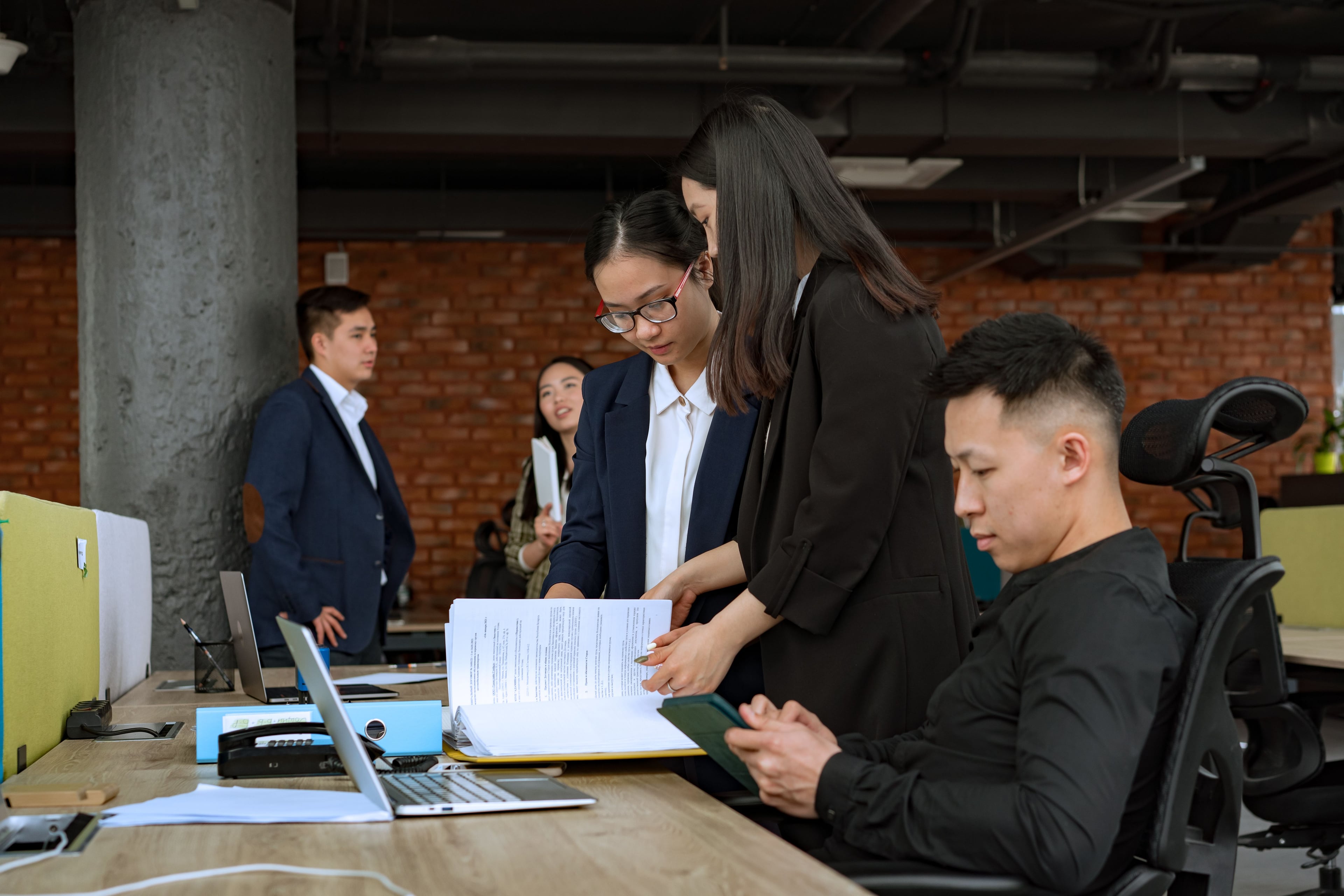 Colleagues comparing information in a document