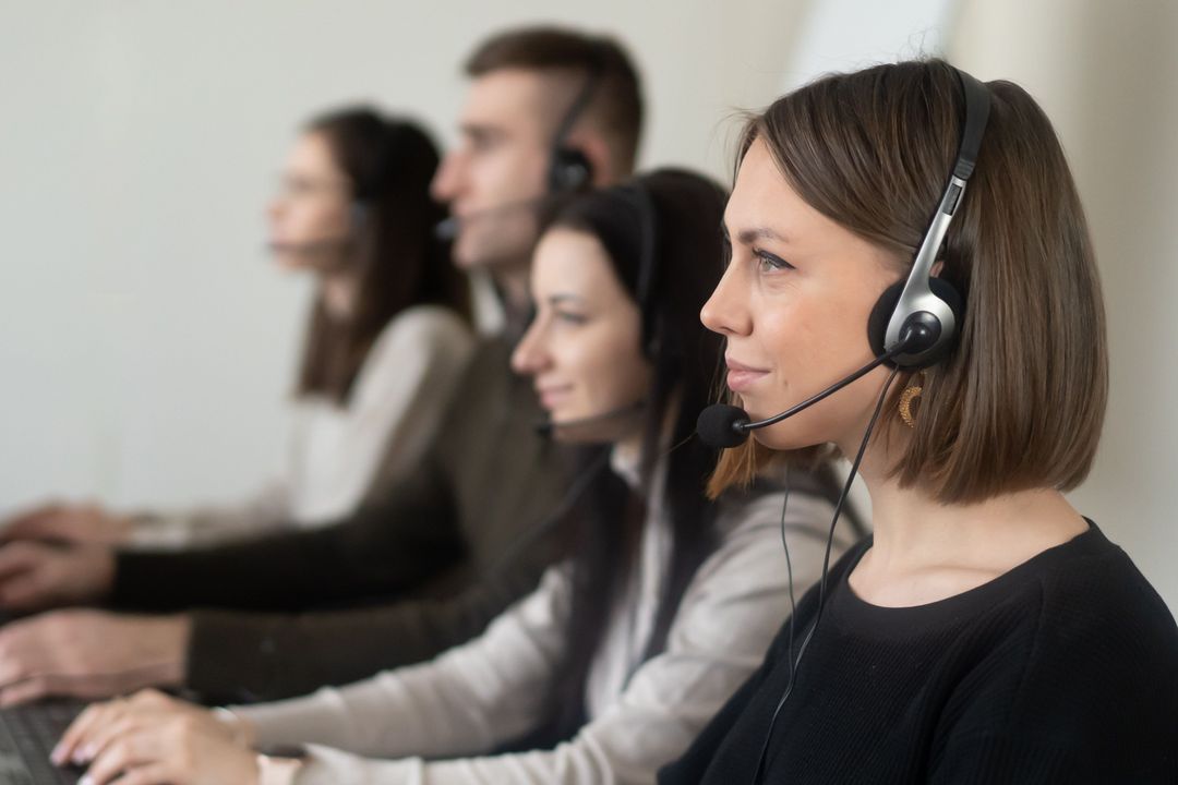 Customer service colleagues using headsets at their desks