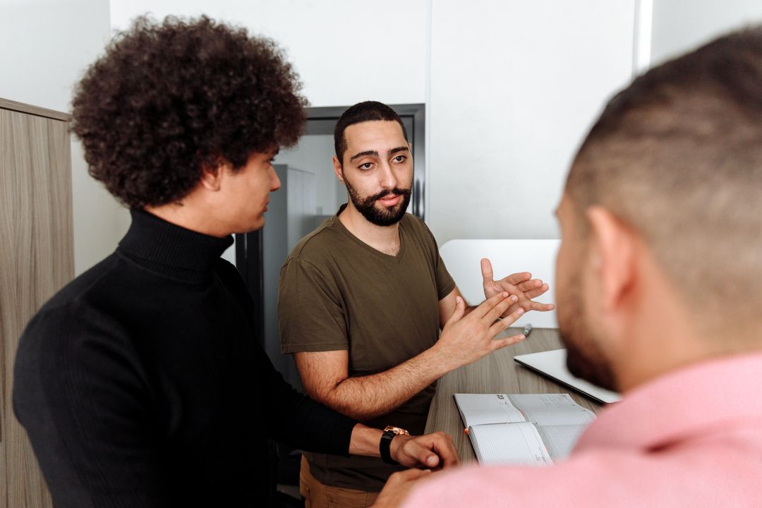 Colleagues discussing notes around a desk